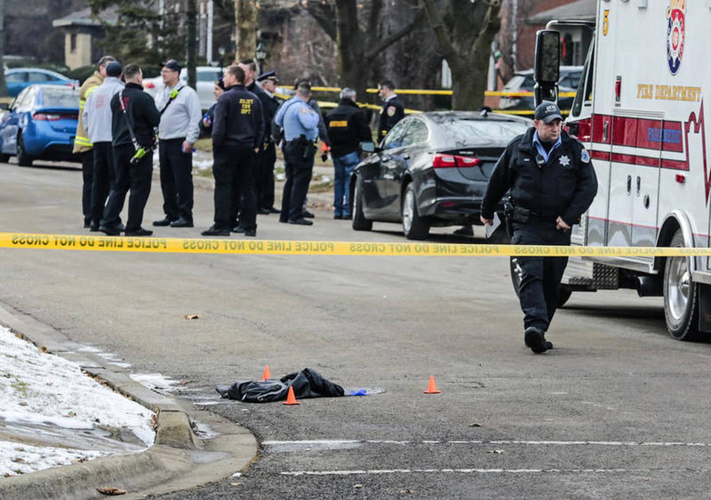 a jacket can be seen on the ground as police and investigators secure the scene of a shooting Friday, Dec. 20, 2019, at Sherwood Place in Joliet, Ill. One male was killed and a female was transported to an area hospital with an injury.
