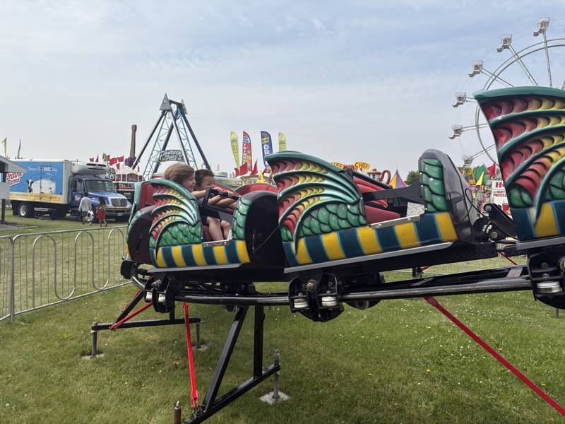 Avery Hoeppner, 5, of Milwaukee, left, rides a ride with Elijah Rudd, 6, of Walworth, Wisconsin, during Harvard Milk Days June 7, 2025.