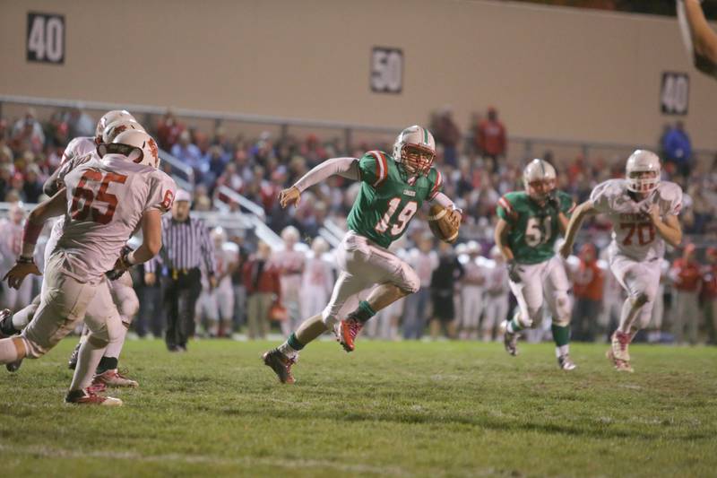 La Salle-Peru quarterback Zack Cinotto (19) looks for running room while Ottawa's Tyler Skolek (65) and Jacob Vanda (70) give pursuit in the 2012 game at Howard Fellows Stadium.