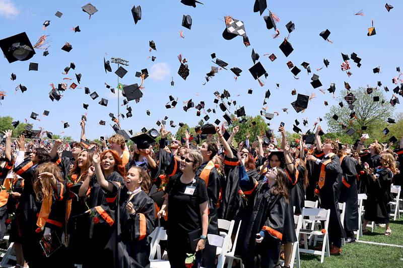 Graduates toss their graduation caps into the air Saturday, May 20, 2023, during the McHenry Community High School Graduation Ceremony for class of 2023 at McCracken Athletic Field in McHenry.