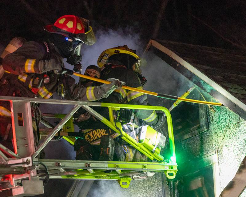 Firefighter atop ladder attempt to open vent on scene of '2nd Alarm' house fire on Saturday, January 10, 2026, at 217 West Delvin Street in Spring Valley.