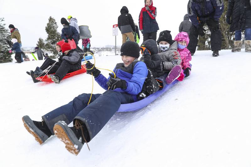 (From left to right) Skylar Sulaica and his siblings Sawyer, Aiden and Amelia prepare to sled down the hill together on Sunday, Jan. 31, 2021, at Cene's Four Seasons Park in Shorewood, Ill.  Nearly a foot of snow covered Will County overnight, resulting in fun for some and challenges for others.