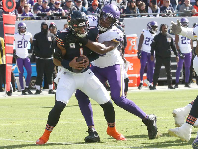 Chicago Bears quarterback Justin Fields is sacked by Minnesota Vikings offensive linebacker DJ Wonnum during the first play of the game on Sunday, Oct. 15, 2023 at Soldier Field.