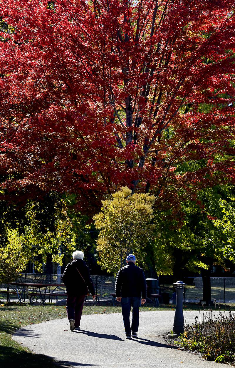 A couple walks on Thursday, Oct. 17, 2024, at Crystal Lake’s Main Beach.