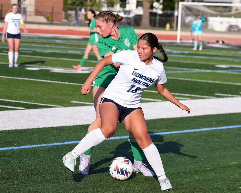 Downers Grove South's Isa Okuku (18) and York's Maggie Quinn (18) battle for the ball during the regional title game on Friday May 23, 2025, held at York High School,