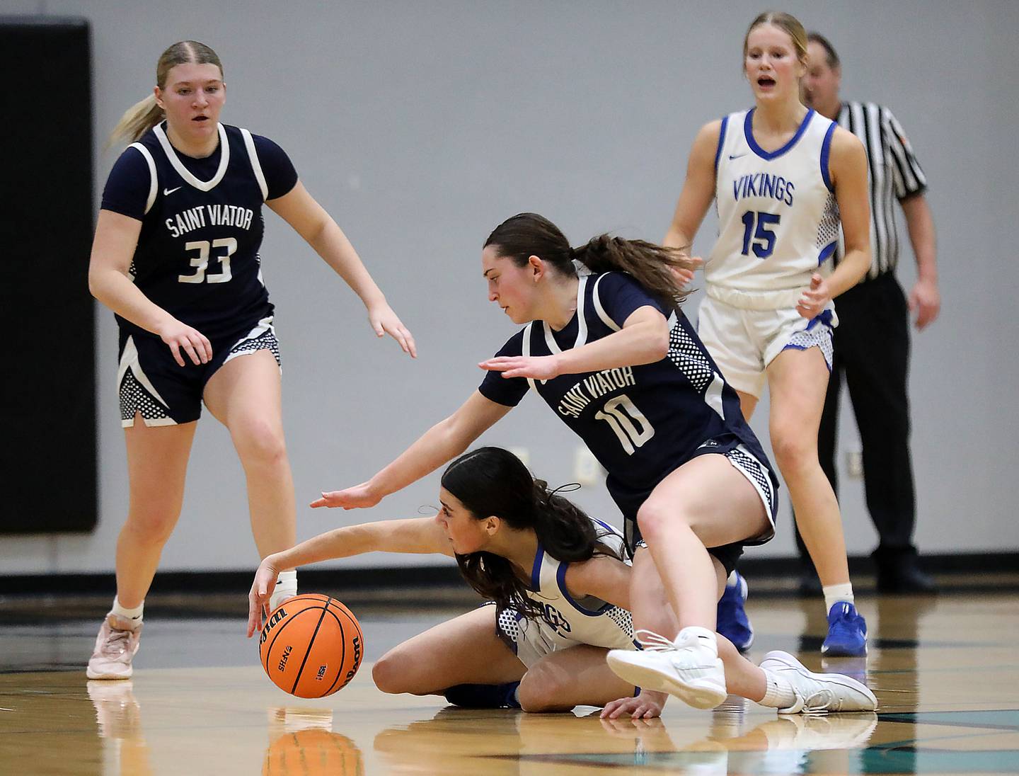 Geneva's Ella Wilkison tries to cater a loose ball as St. Viator's Bella Gounaris reaches for the ball during the IHSA Class 3A Woodstock North Supersectional girls basketball game on Monday, March 2, 2026, at Woodstock North High School.