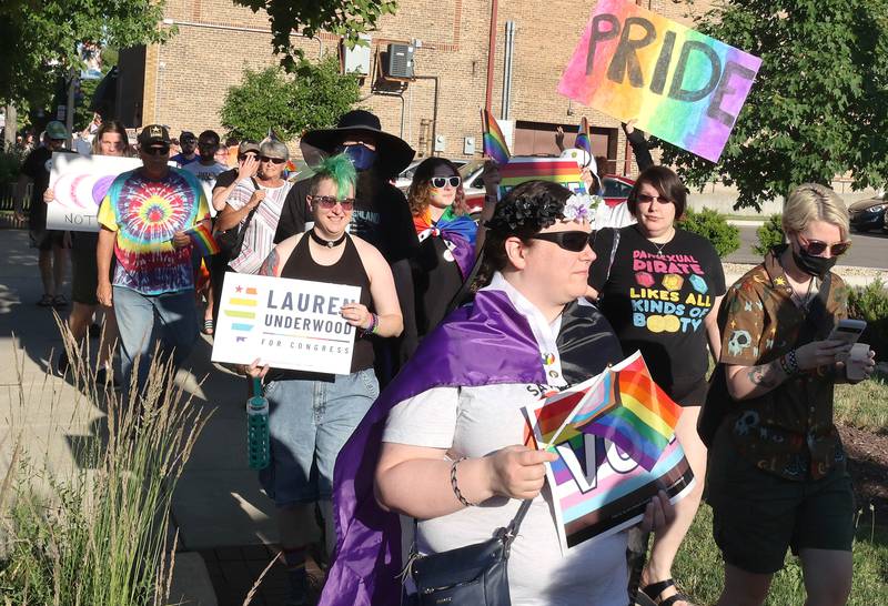 Participants march down the sidewalk on East Locust Street Thursday, June 23, 2022, during a parade to celebrate Pride month in DeKalb. The function included a short parade through downtown and a showing of the movie “Tangerine,” with a panel discussion afterwards at the Egyptian Theatre.