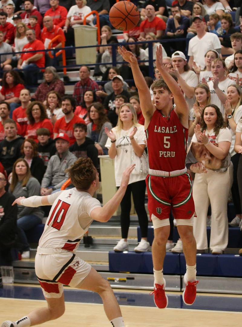 L-P's Seth Adams shoots a three point basket over Metamora's Tyler Mason during the Class 3A Sectional on Tuesday, Feb. 27, 2024 at Pontiac High School.