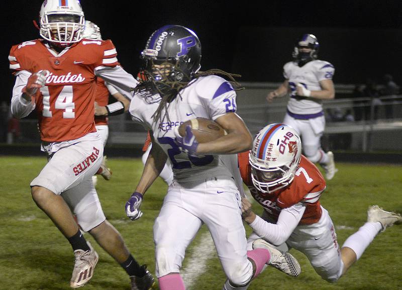 Plano’s Ray Jones Jr works to get past Ottawa’s Trey Donnely and Dillan Quatrain on a run in the 1st quarter Friday at Plano. Oct 22,2021.