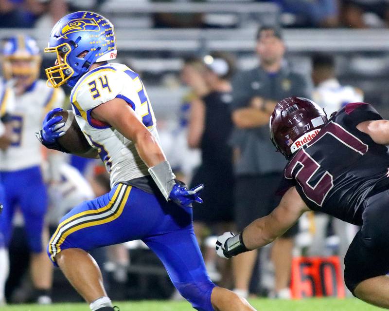 Johnsburg’s Duke Mays runs with the ball past Marengo’s Connor Sacco in varsity football at Rod Poppe Field on the campus of Marengo High School in Marengo on Friday, Oct. 3, 2025.