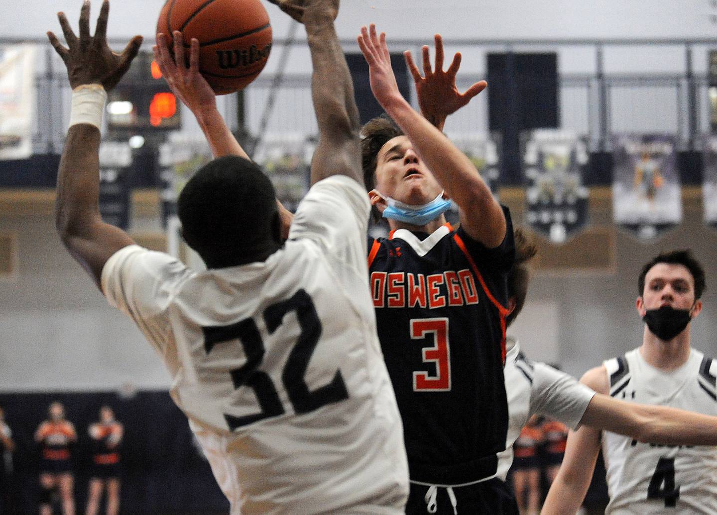 Oswego's Max Niesman (3) makes a tough shot and gets the foul by Oswego East's Gavin Garcon  (32) on Friday, February 11, 2022 at Oswego East High School.