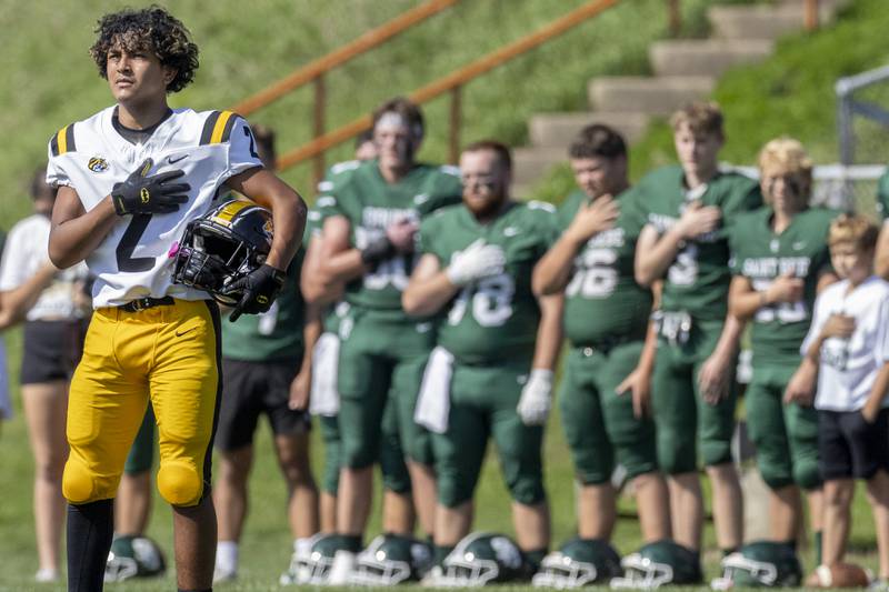 Jacob Solis of Elmwood Park and players  of St. Bede Academy stand together for the National Anthem prior to the game on September 30, 2023.