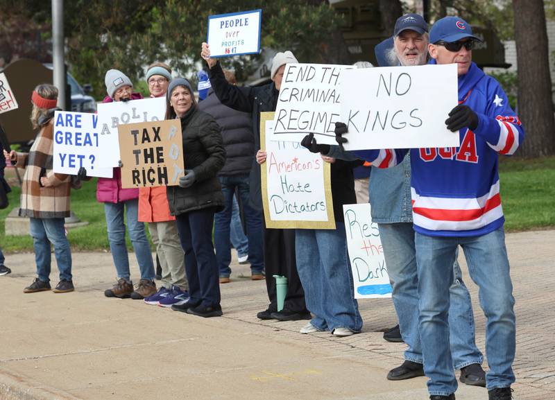 Protesters line First Street Friday, May 1, 2026, during a May Day rally at Memorial Park in downtown DeKalb. The group gathered to advocate for workers’ rights and push for billionaires to be taxed amid cost-of-living burdens they argue are hurting everyday Americans.