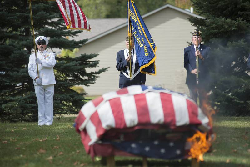 Senior Chief SOCS Michael Allen ret. (left), Ron Wiersema and Jim Prombo of the Morrison American Legion stand in honor as American flags are retired Sunday, Sep. 26, 2021 in Morrison. Flags that are worn and faded are considered to have served their duty and can be honorably burned. The legion retired 307 flags on Sunday.