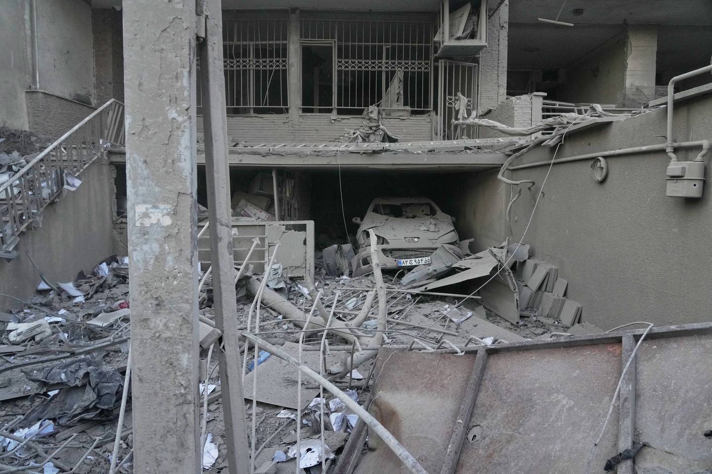 A car is amid the debris of a building damaged by a strike on a police station during ongoing, joint U.S.-Israeli military attacks in Tehran, Iran, Monday, March 2, 2026. (AP Photo/Vahid Salemi)