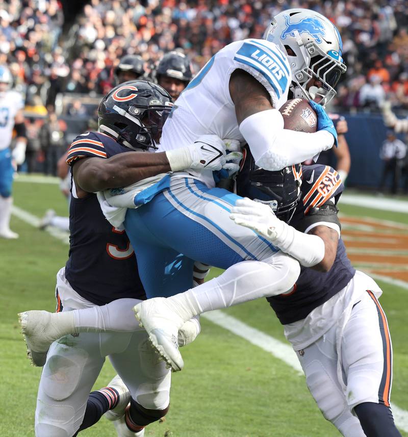 Chicago Bears linebacker Nicholas Morrow (left) and safety Jaquan Brisker bring down Detroit Lions running back D'Andre Swift near the goal line during their game Sunday, Nov. 13, 2022, at Soldier Field in Chicago.