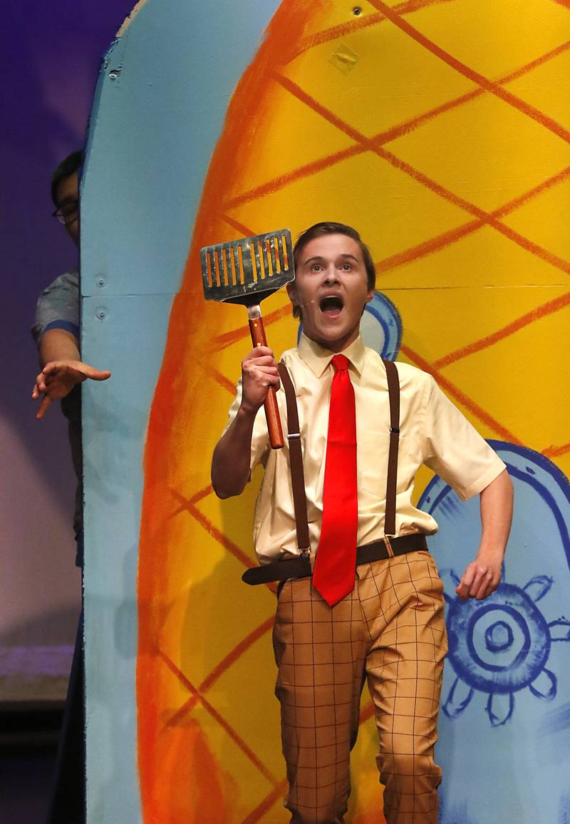 Kadin Henige, playing SpongeBob SquarePants, rehearses a scene from the McHenry Community High School’s production of “The SpongeBob Musical” on Tuesday, March 7, 2023, at the school’s Upper Campus.