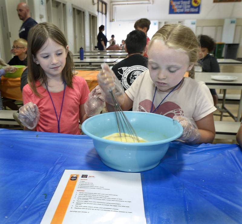 Lexi Gillette and Rebecca Johnson stir up scrambled eggs to make Eggs Ole! on Friday, June 30, 2023, at Northlawn Junior High School in Streator during the Illinois Junior Chefs class. The University of Illinois-Extension, OSF Health, Live Well Streator and Streator Salvation Army coordinated the weeklong program.