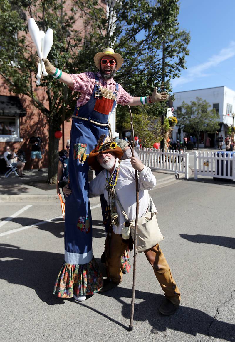 Steve McPhail, (right) a Johnny Appleseed storyteller, jokes around with stil-twalker scarecrow Jason Kollum with during the Johnny Appleseed Festival on Saturday, Sept. 27, 2025, in downtown Crystal Lake. The festival featured live performances, food and family-friendly activities.