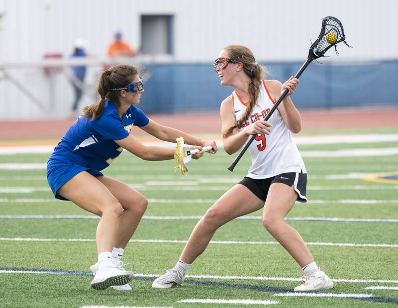Crystal Lake Central's Fiona Lemke looks to pass past the defense of Lake Forest's Caroline Keil during the girls lacrosse supersectional match on Tuesday, May 31, 2022 at Hoffman Estates High School.