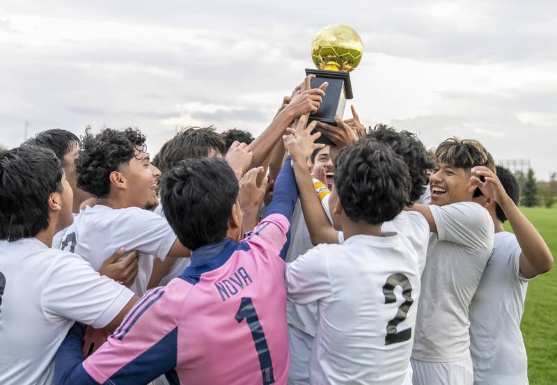 Harvard teammates lift the championship trophy after winning the Kishwaukee River Conference Tournament Championship soccer game against Woodstock North 4 to 1 on Monday, October 6, 2025 at Woodstock North High School. Ryan Rayburn for Shaw Local