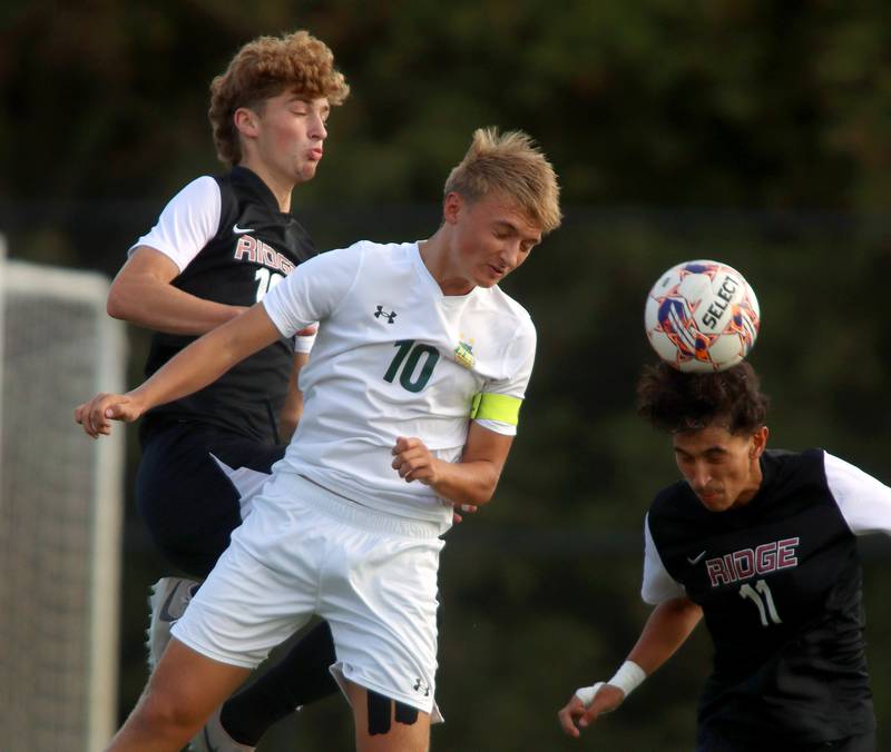 Crystal Lake South’s  Nick Prus, center, battles Prairie Ridge’s Anthony Castro, right, and Chase Santucci, left, in varsity soccer on Thursday, Sept. 19, 2024, at Prairie Ridge High School in Crystal Lake.