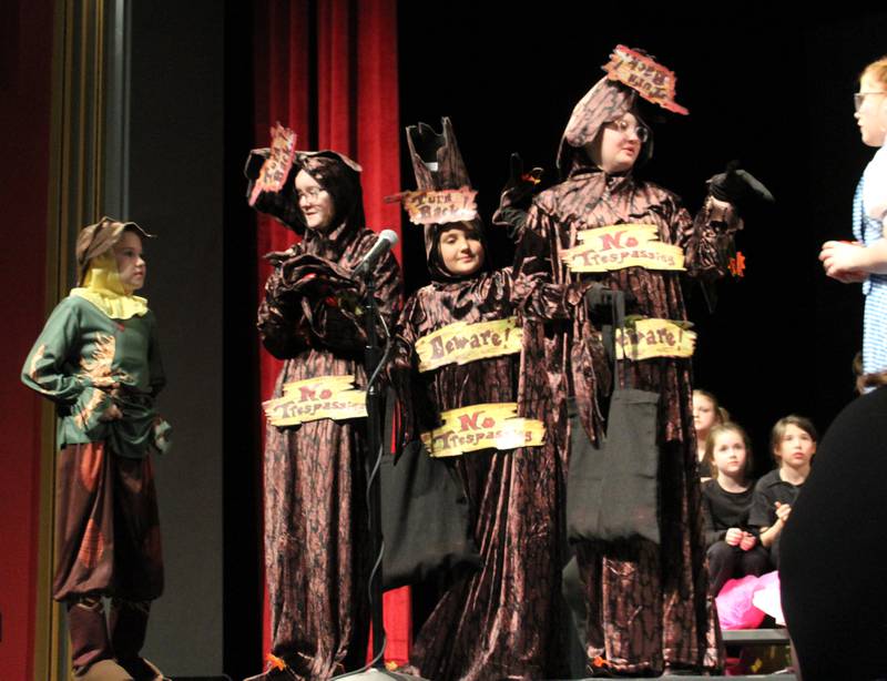 The Scarecrow (Jaxton Anderson), at far left, and Dorothy Gale (Karsyn Stewart), at far right, are confronted by three persnickety apple trees, from left Serenity Krueger, Aubrielle Verduzco and Morgan Handzo, on Friday, March 22, 2024, during the Streator Elementary Schools production of "The Wizard of Oz – Youth Edition" at Streator High School.