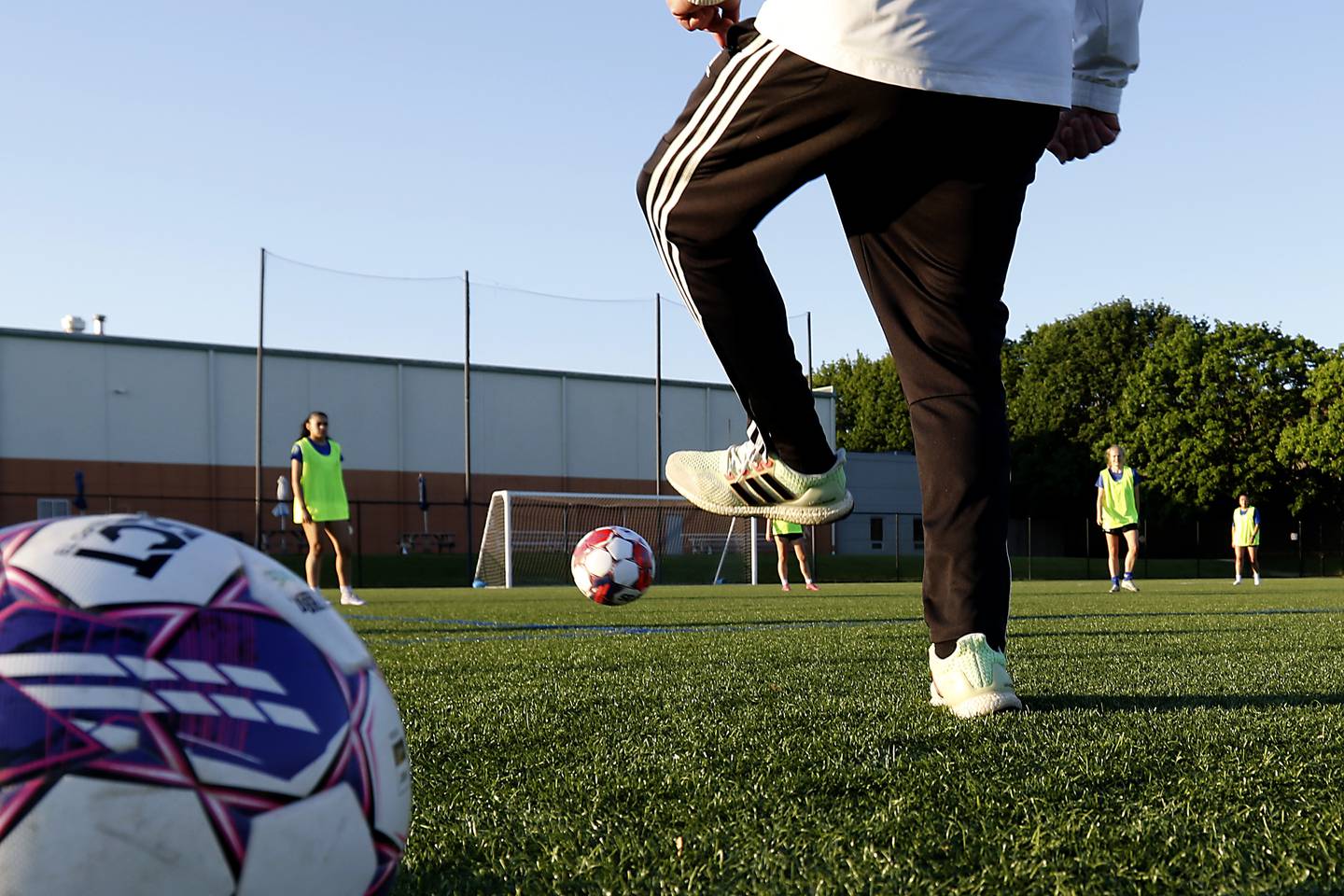 Crystal Lake Force assistant coach Kristian Rockall licks the a ball to start play as he watches as players with the new semi-pro women's soccer team practice on Friday, May 23, 2025, at the MAC sports center in Crystal Lake. The Force is playing in the United Women’s Soccer league and his its first game on Saturday against Edgewater Castle Football Club.