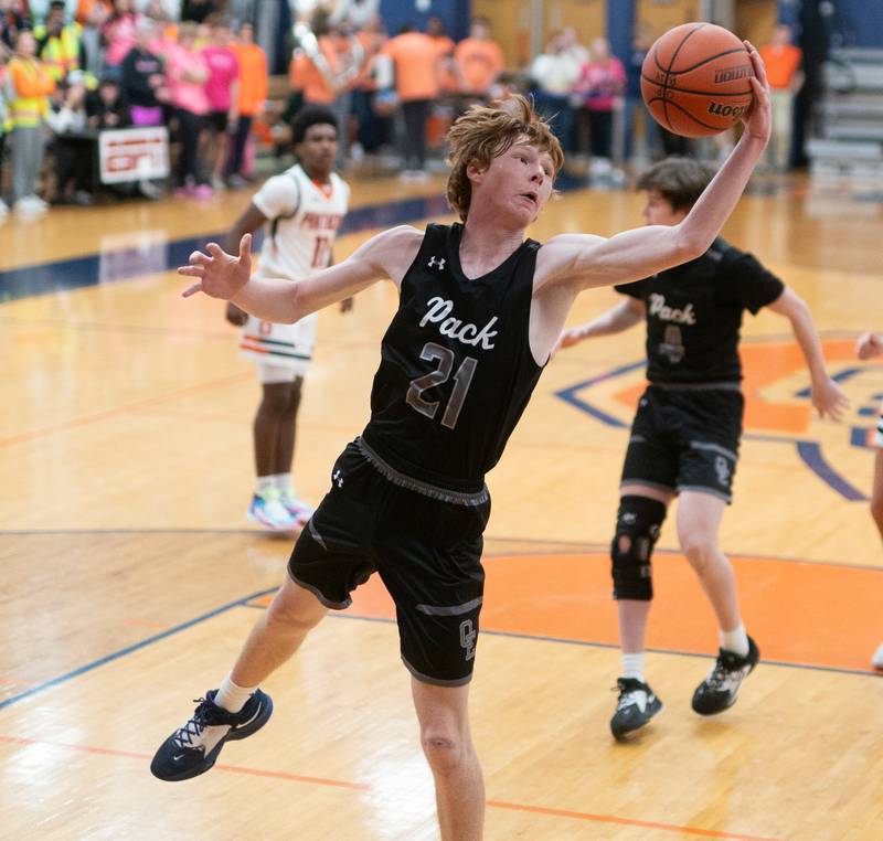 Oswego East's Andrew Pohlman (21) rebounds the ball against Oswego during a basketball game at Oswego High School on Tuesday, Dec 12, 2023.