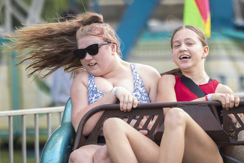 Drey Collins (left), 13, and Anissa Antonsen, 12, of Dixon get thrown around on the Sizzler Wednesday, July 3, 2024 at Petunia Fest.