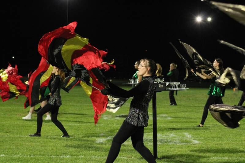 A secret agent's briefcase opens up into brilliant colored flags during a halftime routine by the Rock Falls marching band that included tunes from popular spy films.
