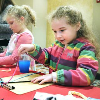 Ellie Langley, (left) 7, and Loretta Cima, 6, both from DeKalb, make jewelry using upcycled T-shirts Thursday, April 18, 2024, during Earth Fest at the Egyptian Theatre in DeKalb. The event, in honor of Earth Week, was presented by DeCarbon DeKalb, in partnership with NIU.