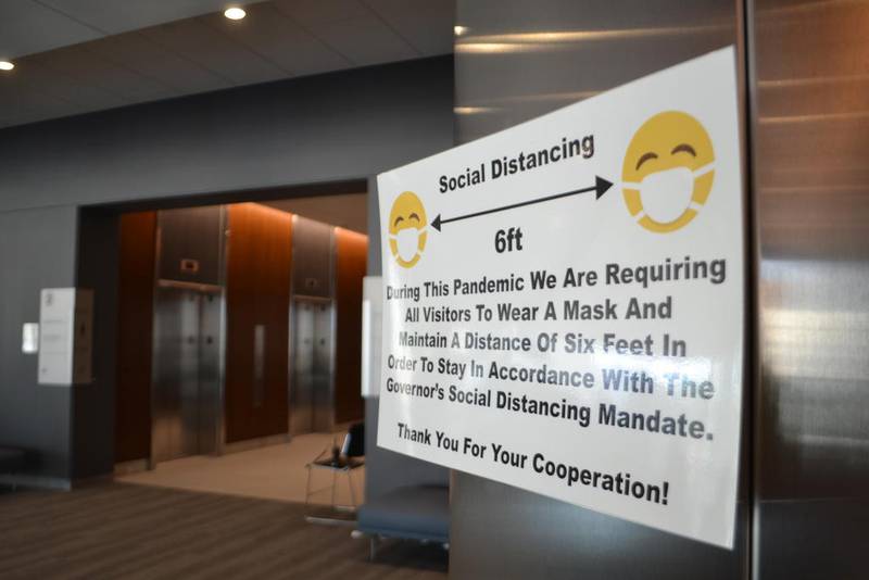 A sign at the new Will County Courthouse reminds visitors to wear a face covering and maintain physical distancing. The courthouse opened for operations Monday.