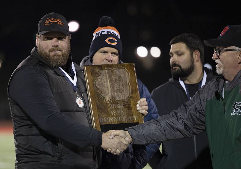 Milledgeville coach Jason Wroble accepts the second place trophy Friday, Nov. 22, 2024, during the 8-man football championship in Monmouth.