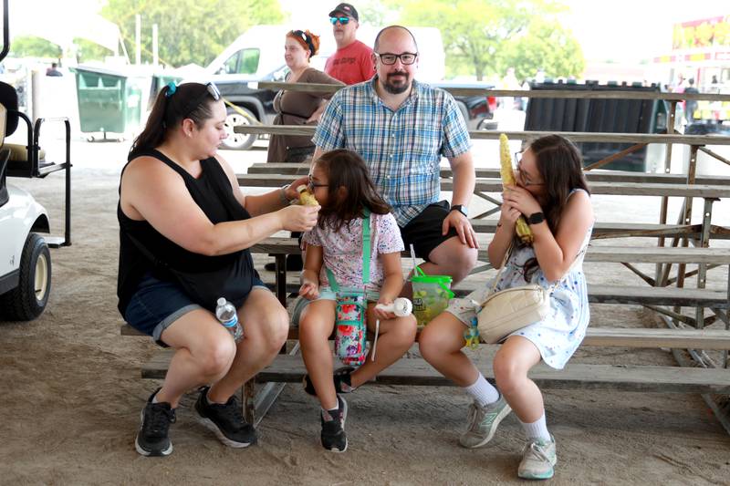 (Left to right) Susan, Ava, 8, Gino and Ruby Fedanzo, 11, of Naperville eat corn at the 155th Kane County Fair in St. Charles on Sunday, July 21, 2024.