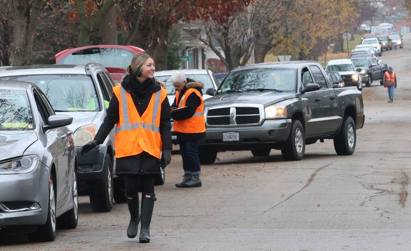 Volunteer Kelli Fiocchi directs a long line of traffic at the corner of 1st and Terry Street during the Thanksgiving distribution on Wednesday, Nov. 19, 2025 at the Hall Township Food Pantry in Spring Valley. Nearly 500 families will receive food from this years distribution.