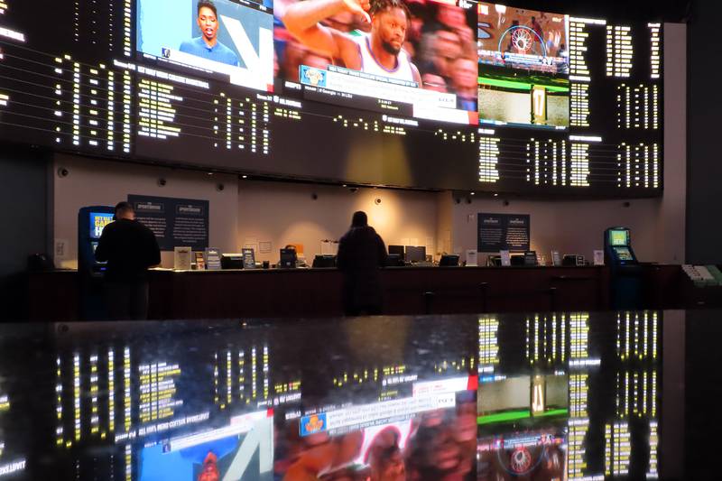 People make bets at the sportsbook at the Ocean Casino Resort, on Thursday, Feb. 10, 2022, in Atlantic City, N.J. The American Gaming Association estimates more than 31 million Americans will bet on this year's Super Bowl NFL football game. (AP Photo/Wayne Parry)