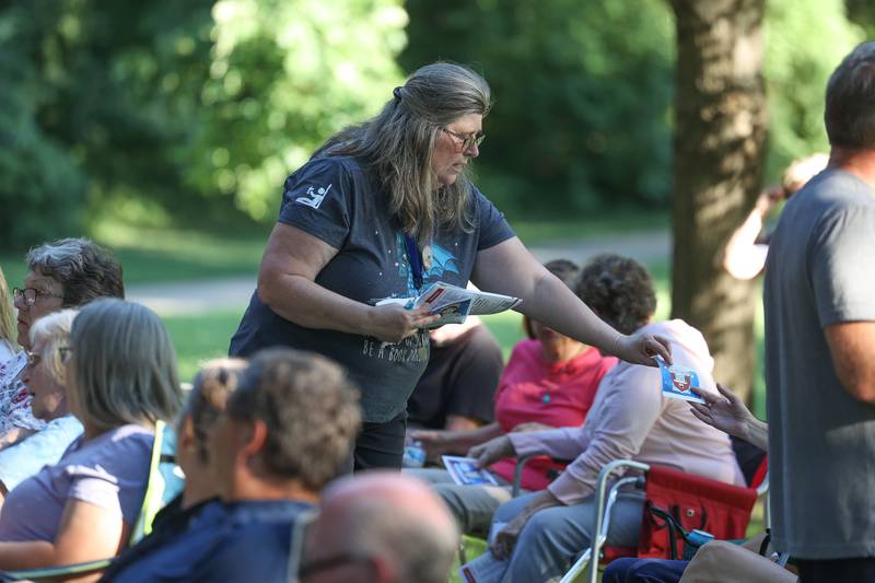 Pam Burton, Morris Library Program Manager, hands out fliers for upcoming events at the GreenRoom Improv show hosted by the Morris Library at Goold Park on Friday, Aug. 11, 2023 in Morris.
