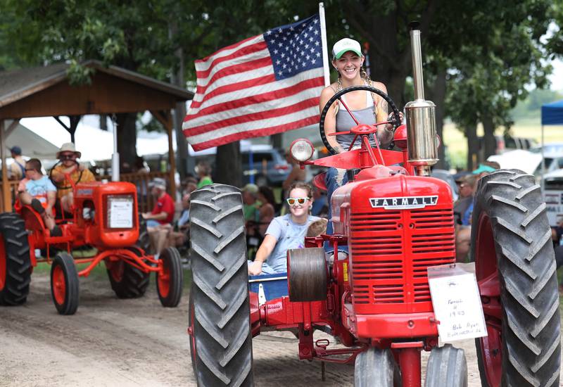 Emma Duffield, from Byron, drives a 1943 Farmall H tractor through the parade Thursday, Aug. 7, 2025, at the 68th annual Sycamore Steam Show and Threshing Bee at Taylor Marshall Farm on Lukens Road in Sycamore.