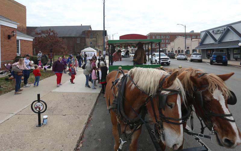 A team of horses pull a group of people in front of the Prouty Community Building during the annual Christmas Walk on Saturday, Nov. 22, 2025 in Princeton.