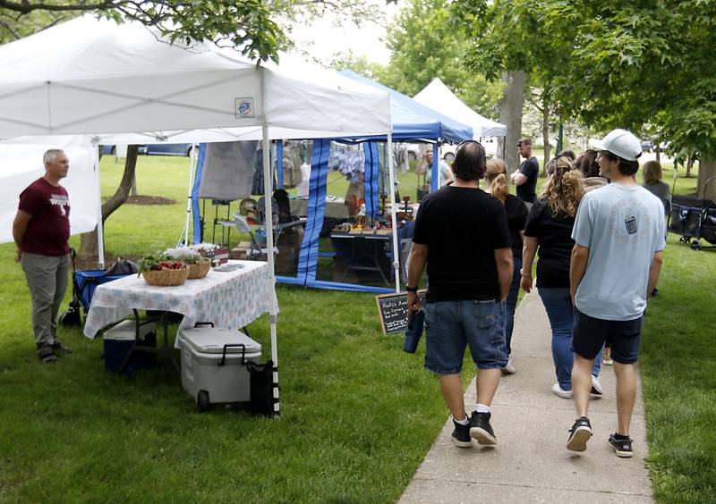 Kristopher Muse of Wild Thyme Biologic. Talks with people as the shop Thursday, May 16, 2024, during McHenry's Pearl Street Market and concert at Veteran's Memorial Park. The market features around 35 venders and live music on Thursdays through Sept. 19.