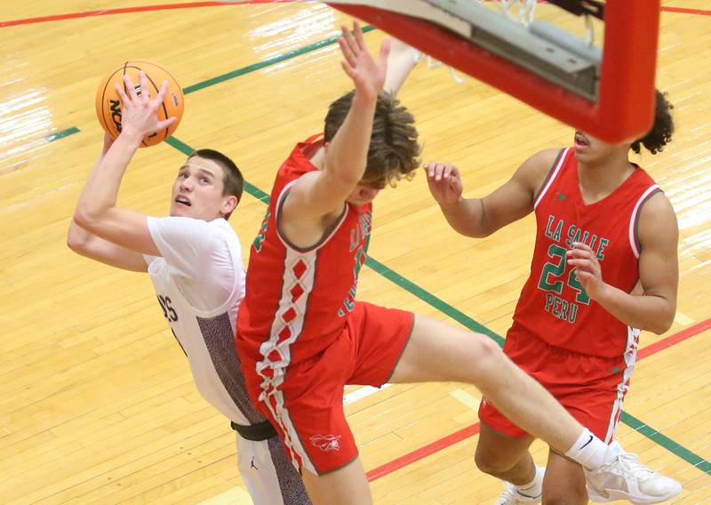 Dixon's Cullen Shaner eyes the hoop as L-P's Braylin Bond draws a foul during the Class 3A Regional semifinal game on Wednesday, Feb. 26, 2025 in Sellett Gymnasium at L-P High School.