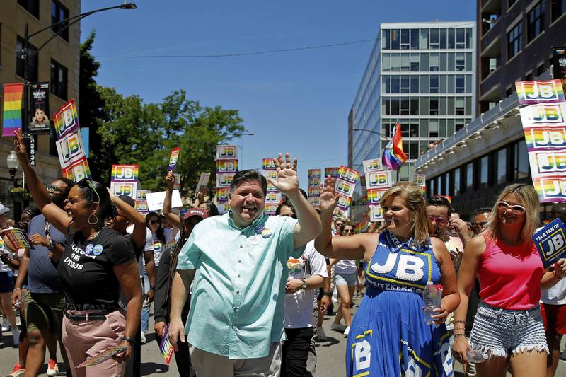 Illinois Gov. JB Pritzker, center left, and his wife, MK, center right, wave to the crowd during the Chicago Pride Parade in Chicago, Sunday, June 26, 2022. (AP Photo/Jon Durr)