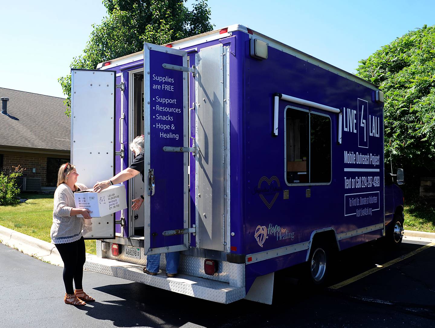 Stefanie Gattone, the McHenry County program manager of Live4Lali, hands a box to Laura Fry, the nonprofit's executive director, as they load supplies on their truck before a meeting Monday, June 27, 2022, of the McHenry County Substance Abuse Coalition in Crystal Lake. Live4Lali is one of nearly 60 agencies being asked how McHenry County should spend the Big Pharma settlement in battling opioid addiction in McHenry County.