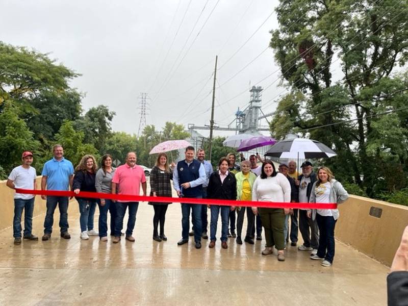 Morris Mayor Chris Brown is surrounded by local officials as they cut the ribbon on the Calhoun Street Bridge.