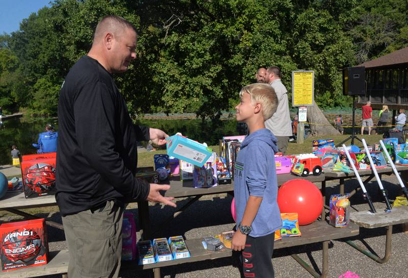 Whiteside County Chief Deputy Jeff Venhuizen teases Tyler Houzenga, 11, of Fulton, about choosing a toddler-age prize during the sheriff department's annual fishing derby at Morrison-Rockwood State Park on Saturday, Sept. 9, 2023. Houzenga chose an age-appropriate football after making several trips around the prize table.