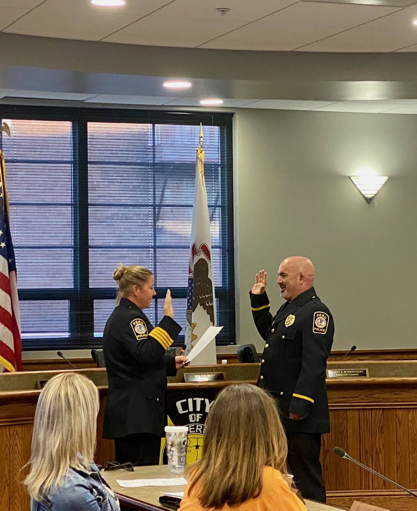 Peru Police Chief Sarah Raymond reads the oath to Officer Brad Jones promoting him Sergeant during Monday nights city council meeting.