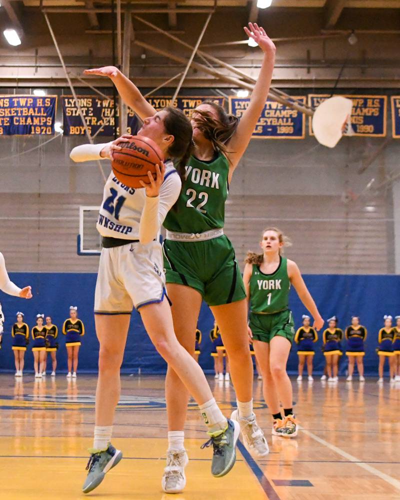Lyons Township Ally Cesarini, left, goes up and makes a basket while York Stella Kohl (22) tries to block the shot during the second quarter on Friday Feb. 3rd held at Lyons Township High School.