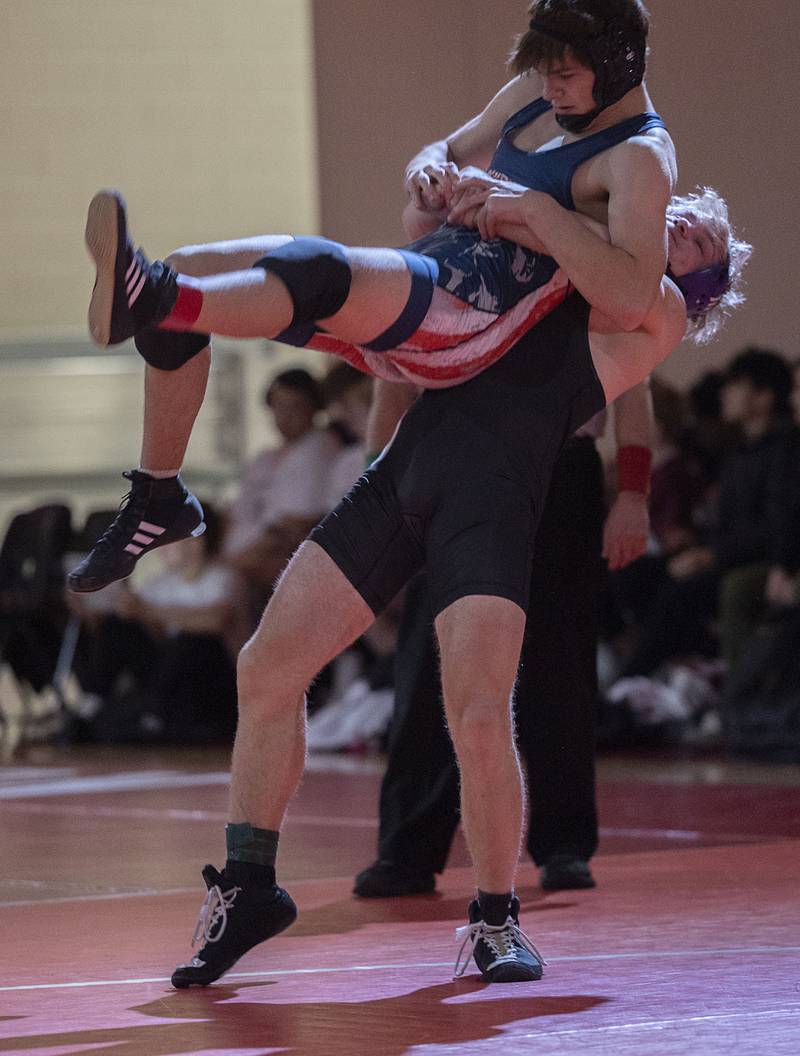 Dixon’s Adam Staples hoists Morrison’s Conrad Eichman in the 165 pound weight class in the Class 1A wrestling sectionals at Oregon.