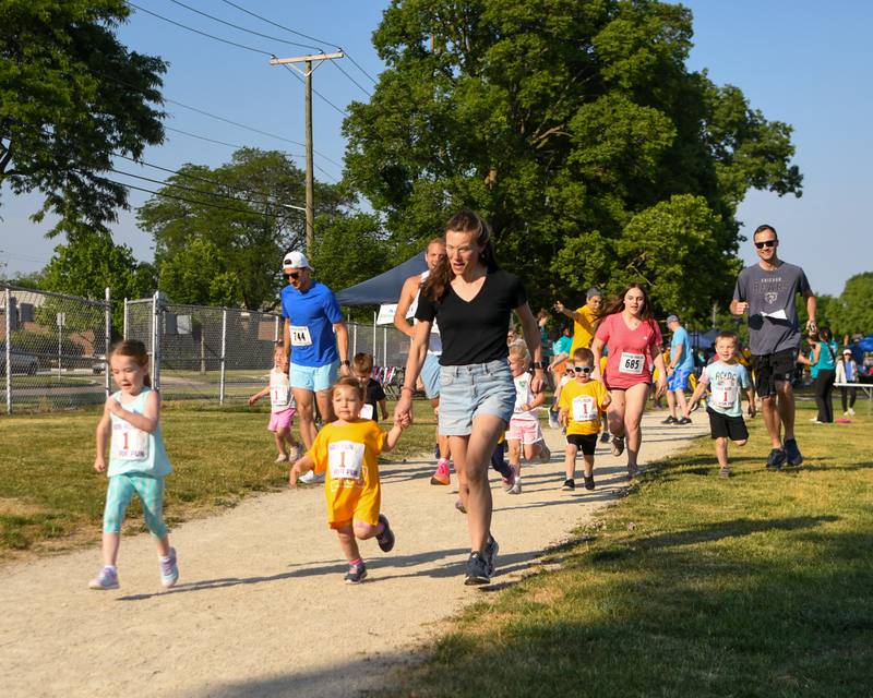 Runners and walkers of all ages take a lap on the track of the Lyons Township practice field during the Leadership event held in La Grange on Friday June 9, 2023.